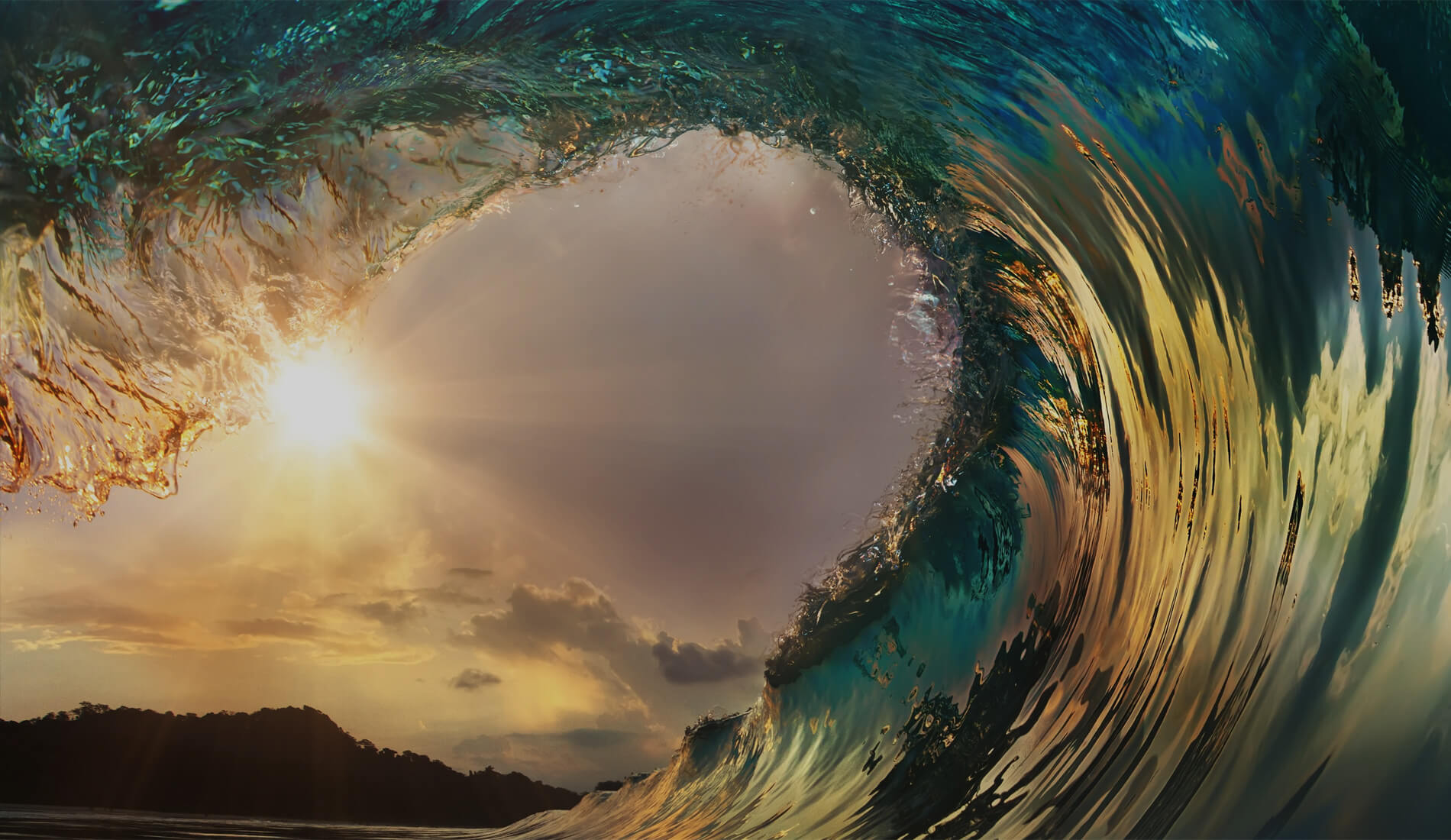 Sunset view through curling ocean wave.
