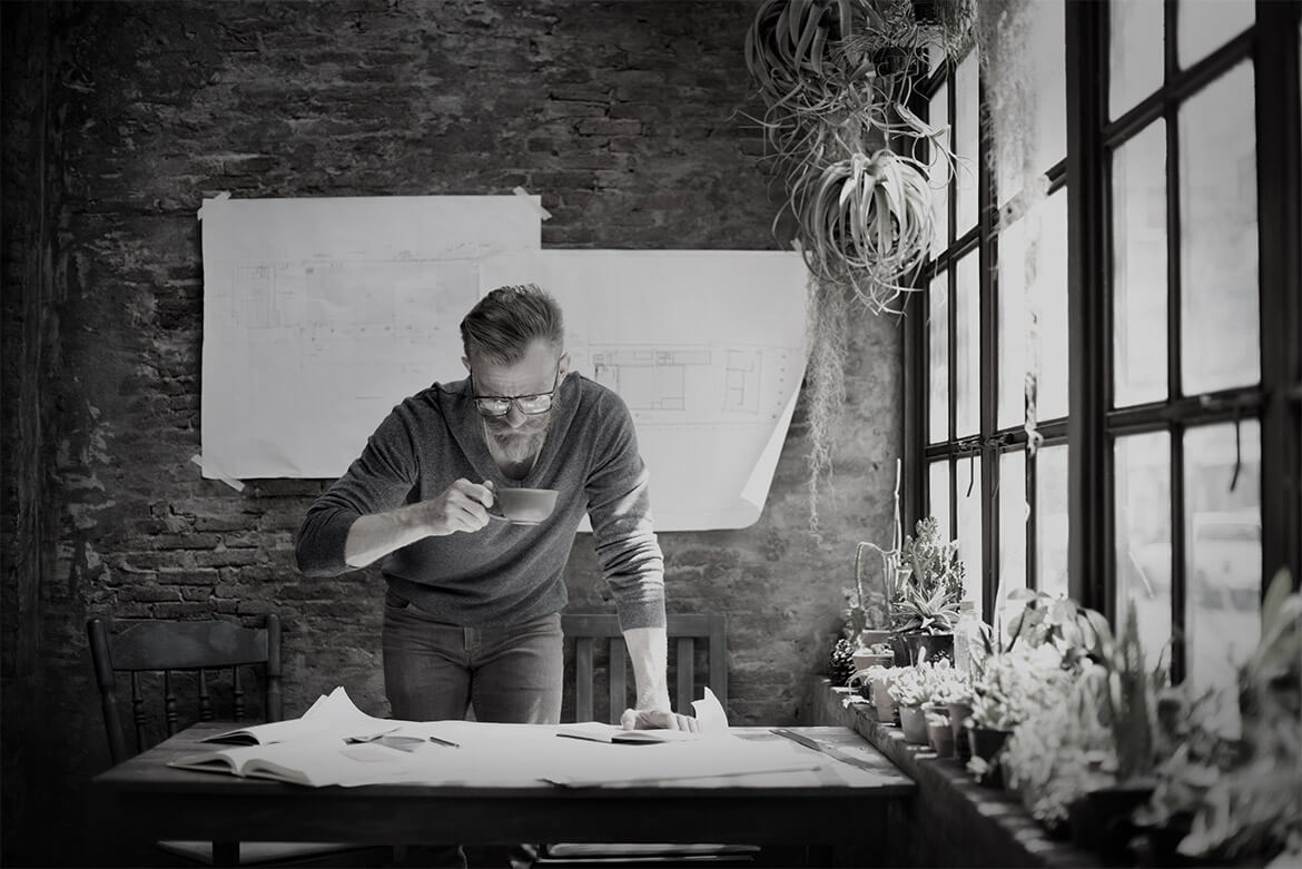 Man working intently on a project in a rustic studio with natural light.