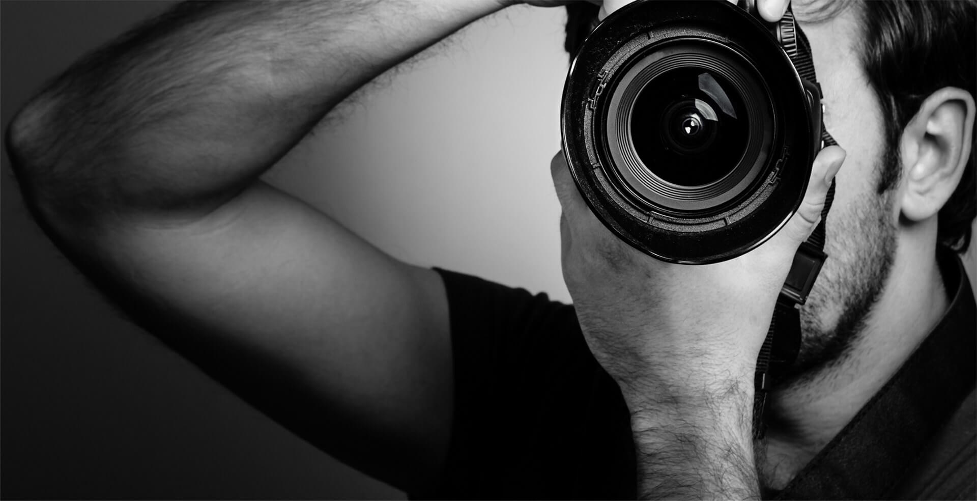 Photographer holding camera, capturing a shot.