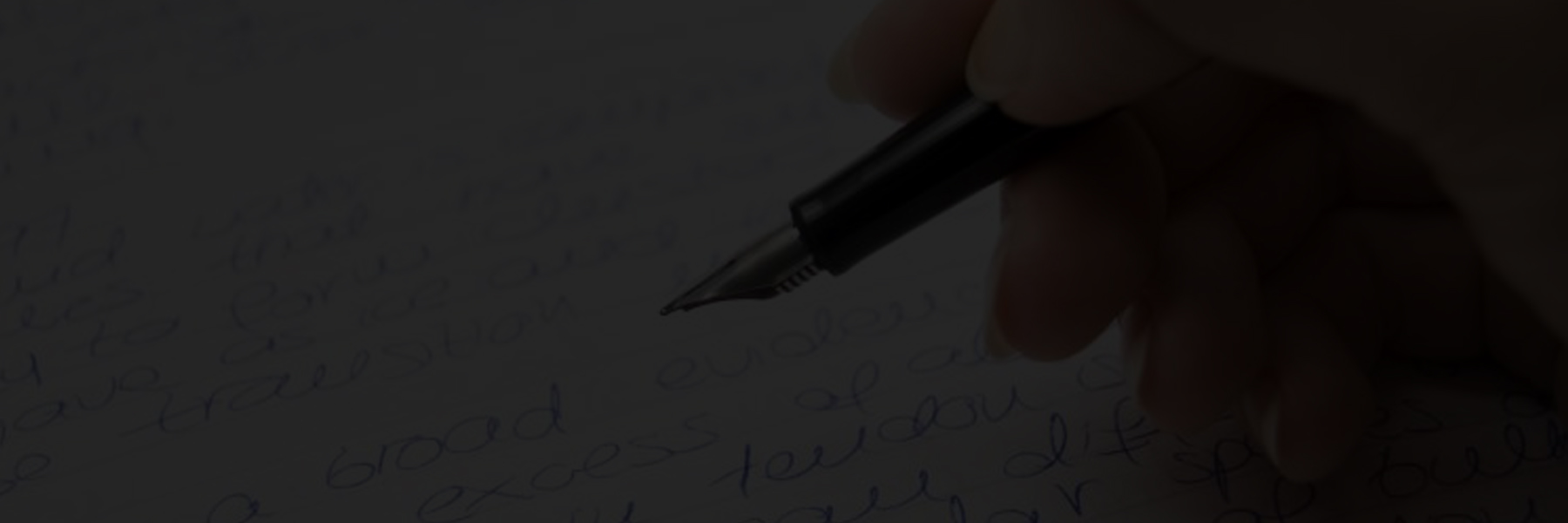Close-up of a hand writing with a fountain pen on paper.