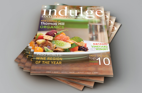 A stack of Indulge magazines featuring gourmet food on the cover.