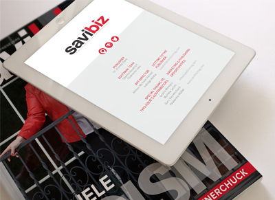 Tablet displaying Savibiz website on a magazine.