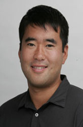 Smiling man in a dark collared shirt.